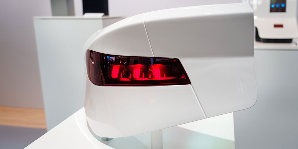 Topic-model of the backlight of a car with a glossy white surface and striking red light.