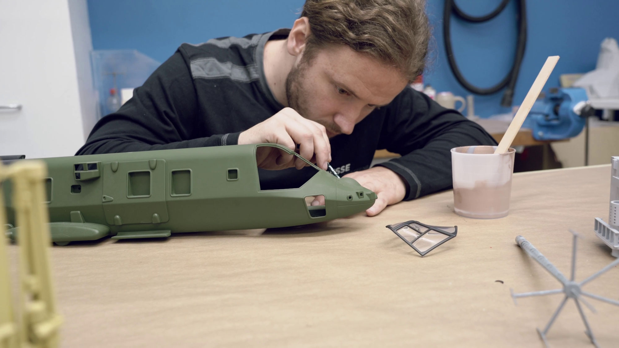 A person prototyping a model airplane at a workbench.